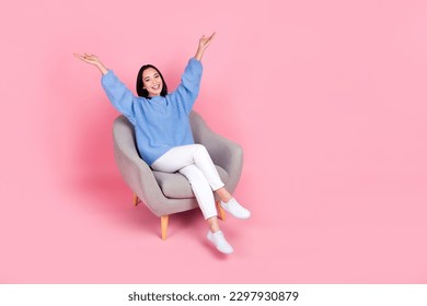 Full body photo of cheerful nice lady sit chair raise arms empty space ad isolated on pink color background - Shutterstock ID 2297930879