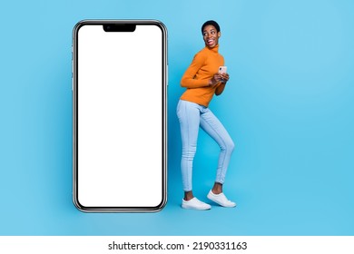 Full body photo of cheerful trans identity bi woman use smartphone see empty copy blank space isolated on blue color background - Powered by Shutterstock