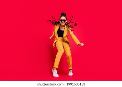 Full body photo of cool lady dance wear eyewear yellow suit isolated on vivid red color background