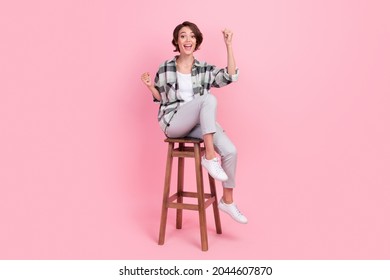 Full body photo of cool millennial brunette lady sit wear shirt trousers isolated on pink background