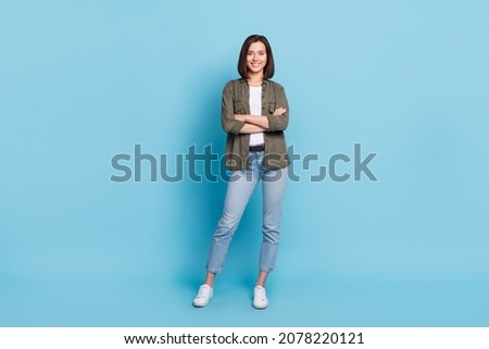Full body photo of cool satisfied glad lady stand with folded arms wear khaki clothes isolated over sky light color background