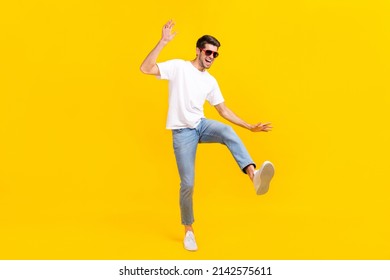 Full Body Photo Of Cool Young Brunet Guy Dance Wear Eyewear T-shirt Jeans Footwear Isolated On Yellow Background