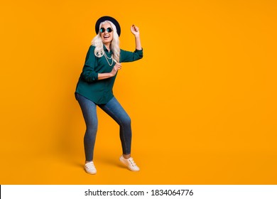 Full body photo of crazy granny lady music lover senior party luxury cool look dance youth moves wear green shirt sun specs necklace retro cap shoes isolated yellow color background