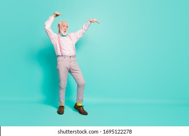 Full Body Photo Of Crazy Old Retired Man Dance Vintage Concert Event Raise Hands Wear Pink Shirt Grey Trousers Shoes Isolated Over Turquoise Color Background