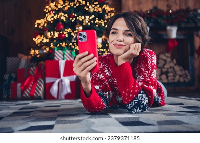 Full body photo of cute lady video call friends waiting santa claus hold iphone send wishlist shopping isolated xmas tree background - Powered by Shutterstock