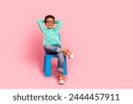 Full body photo of cute little boy sit chair hands behind head specs dressed stylish cyan clothes isolated on pink color background