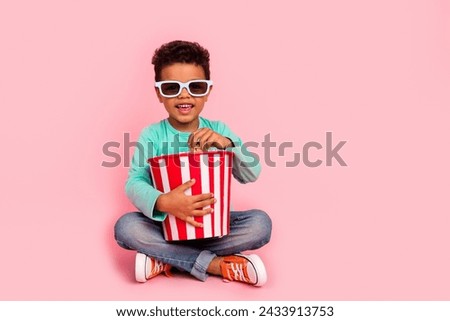 Full body photo of cute little boy eating popcorn 3d glasses sit floor wear trendy aquamarine clothes isolated on pink color background