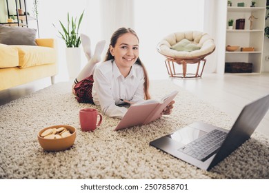 Full body photo of cute teen schoolgirl write notebook snacks lying floor netbook wear uniform home education concept school interior - Powered by Shutterstock