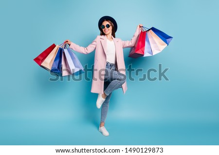 Full body photo of dancing rejoicing girl go shopping buy bargains wear retro pink vintage stylish outfit denim jeans eyewear eyeglasses isolated over blue background