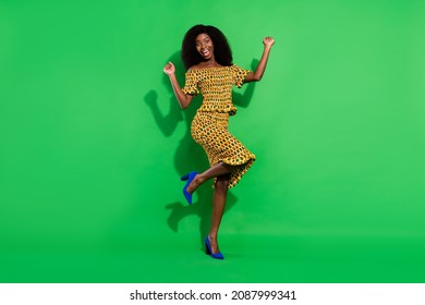 Full body photo of delighted dark skin person fists up open mouth celebrate isolated on green color background