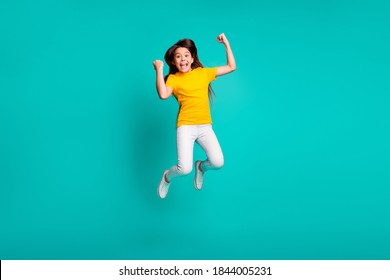 Full Body Photo Of Delighted Kid Girl Jump High Raise Fists Wear White Pants Yellow T-shirt Isolated Over Teal Color Background