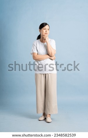 full body photo of an elderly woman posing on a blue background