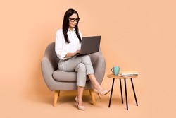 Full Body Photo Of Elegant Company Ceo Lady Sit Cozy Chair Use Netbook Networking Isolated On Beige Color Background