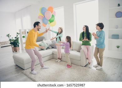 Full Body Photo Of Energetic Fun People Celebrate Family Day Dad Daddy Give Present Gift Surprise His Three Small Schoolgirls Mom Mommy Sit Cozy Couch Clap Hands Enjoy Fest In House Room