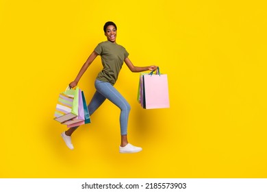 Full Body Photo Of Energetic Person Step Walk Go Jump Hold Packages Isolated On Yellow Color Background