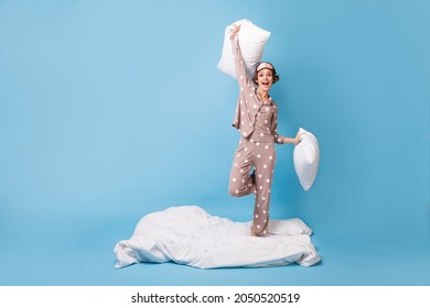 Full Body Photo Of Excited Cheerful Woman Hold Pillows Stand Blanket Sleepover Isolated On Blue Color Background