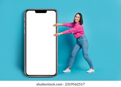 Full body photo of excited filipino lady hands pull huge empty space smart phone isolated on blue color background - Shutterstock ID 2319562517