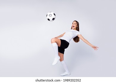 Full body photo of excited lady player soccer team kick leg control ball showing freestyle tricks wear football uniform t-shirt shorts boots knee socks isolated white color background