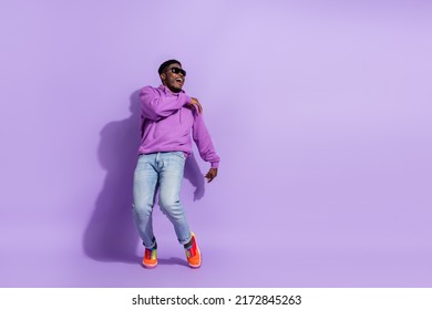 Full body photo of excited positive man rejoice clubbing spend pastime isolated on purple color background