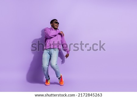 Full body photo of excited positive man rejoice clubbing spend pastime isolated on purple color background