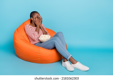 Full Body Photo Of Frightened Horrified Girl Sit Bag Arms Cover Face One Eye Peek Empty Space Isolated On Blue Color Background