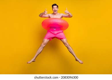 Full body photo of funky millennial guy jump wear buoy pink shorts isolated on yellow background - Powered by Shutterstock