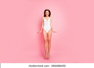 Full body photo of funny lady jumping smiling dressed swimwear isolated over pink background