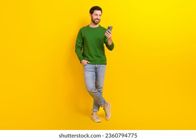 Full body photo of funny professional smm manager content maker blogger young guy hold apple iphone isolated on yellow color background - Powered by Shutterstock