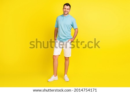 Full body photo of good brunet man stand wear blue t-shirt shorts isolated on yellow color background