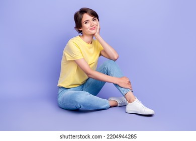 Full Body Photo Of Gorgeous Satisfied Lady Sit Floor Hand Touch Cheek Isolated On Violet Color Background