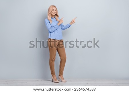 Full body photo of gorgeous woman direct fingers empty space ads adv wear office clothes isolated over grey concrete wall background