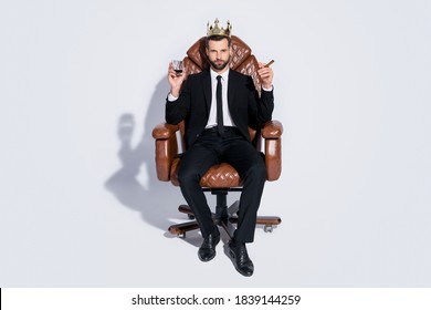 Full body photo of handsome business guy sit office chair hold whiskey glass cuban cigar luxury chief golden crown wear black blazer pants tie shirt shoes suit isolated grey background
