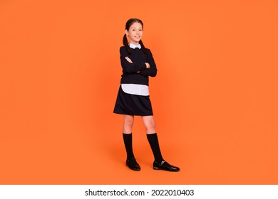 Full Body Photo Of Happy Cheerful Little Girl Hold Hands Crossed Academic Isolated On Orange Color Background