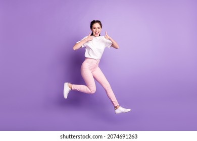 Full Body Photo Of Happy Funky Young Woman Jump Up Smile Make Thumbs Up Isolated On Violet Color Background