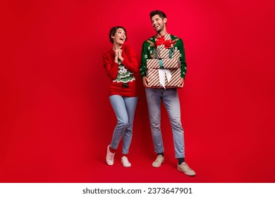 Full body photo of impressed overjoyed people hold pile stack x-mas time giftbox isolated on red color background - Powered by Shutterstock