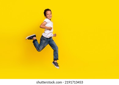 Full Body Photo Of Little Boy Run Wear T-shirt Jeans Sneakers Isolated On Yellow Color Background