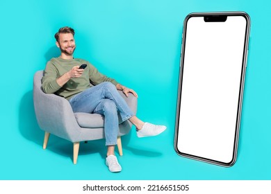 Full body photo of millenial guy watch tv wear shirt jeans sneakers isolated on turquoise background