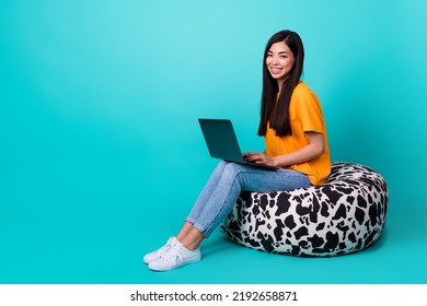 Full Body Photo Of Nice Brunette Lady Sit With Laptop Near Promo Wear T-shirt Jeans Boots Isolated On Turquoise Color Background