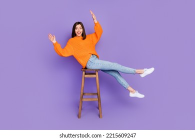 Full Body Photo Of Nice Young Lady Sit Bar Chair Lose Balance Falling Wear Trendy Orange Knitwear Look Isolated On Violet Color Background