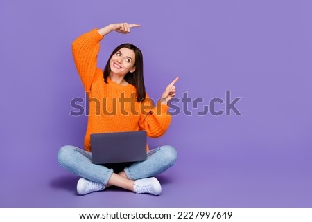Full body photo of nice young girl netbook look direct empty space wear trendy orange knitwear garment isolated on violet color background