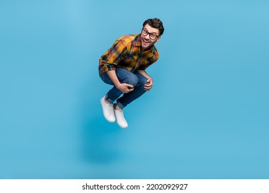 Full body photo of overjoyed glad person jumping falling toothy smile isolated on blue color background - Shutterstock ID 2202092927