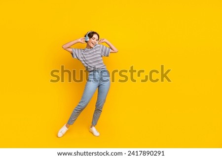 Full body photo of overjoyed young lady arms touch headphones dance empty space ad isolated on yellow color background