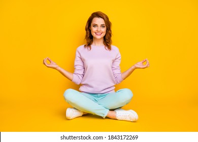 Full body photo of positive cheerful girl sit floor legs crossed meditate yoga show om sign wear pink turquoise outfit white gumshoes isolated over bright color background
