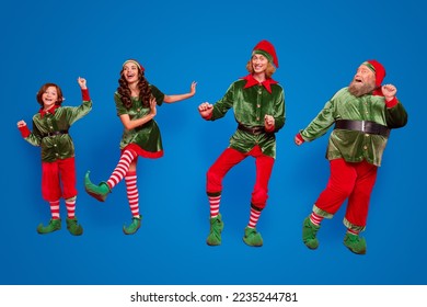 Full body photo of positive childhood elf people dance xmas wear hat holiday enjoy isolated on red color background