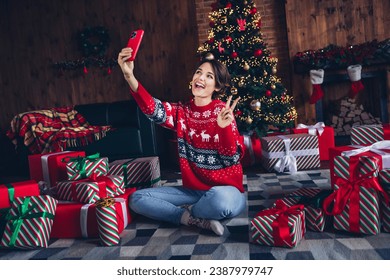 Full body photo of positive girl show v sign holding selfie smartphone demonstrating followers much gift boxes isolated home new year decor