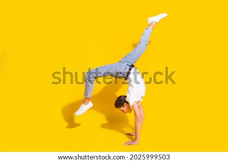 Similar – Man practicing yoga, handstand against a yellow wall