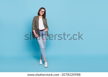 Full body photo of positive intelligent lady hold netbook stand empty space isolated over sky light color background