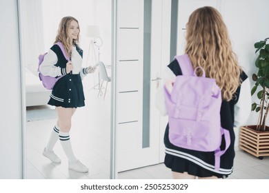 Full body photo of pretty teen girl hold device look mirror wear stylish school uniform morning routine white interior bedroom apartment - Powered by Shutterstock