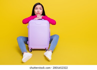 Full Body Photo Of Sad Brunette Millennial Lady Sit With Bag Look Empty Space Wear Pink Sweater Jeans Isolated On Yellow Background