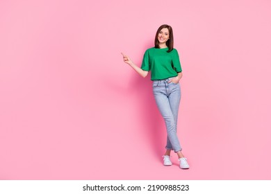 Full body photo of stunning young girl hold hand pocket point empty space dressed trendy green clothes isolated on pink color background